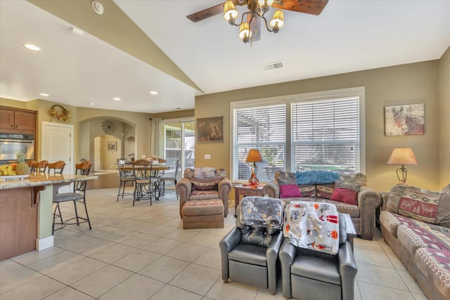 living room featuring a ceiling fan, visible vents, arched walkways, light tile patterned floors, and recessed lighting