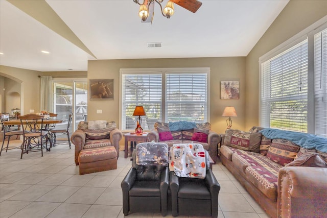 living room with light tile patterned floors, vaulted ceiling, and a healthy amount of sunlight