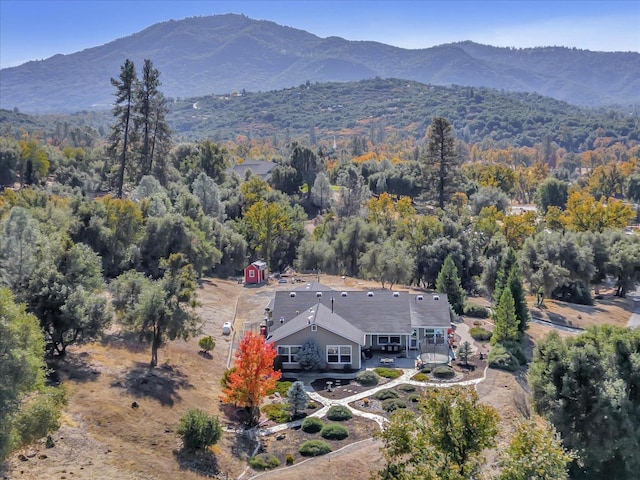drone / aerial view featuring a mountain view and a wooded view
