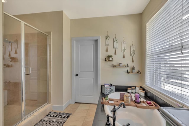 full bathroom with baseboards, tile patterned flooring, a shower stall, and a bath