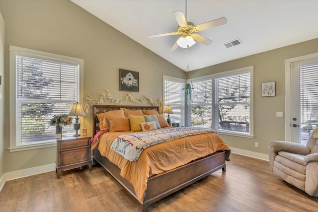 bedroom with visible vents, multiple windows, wood finished floors, and lofted ceiling