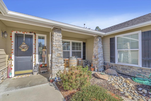 property entrance with a porch and stone siding
