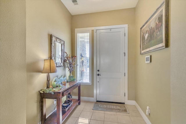 foyer entrance featuring baseboards, visible vents, and light tile patterned floors
