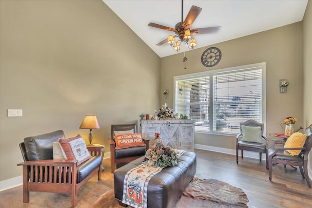 sitting room with baseboards, ceiling fan, wood finished floors, and high vaulted ceiling
