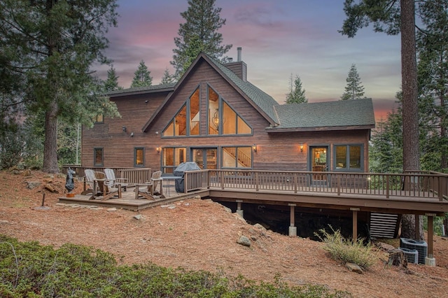 40596 Wild Iris Ln, Shaver Lake, CA 93664 - rear view of house featuring a wooden deck, a shingled roof, a chimney, and central AC unit