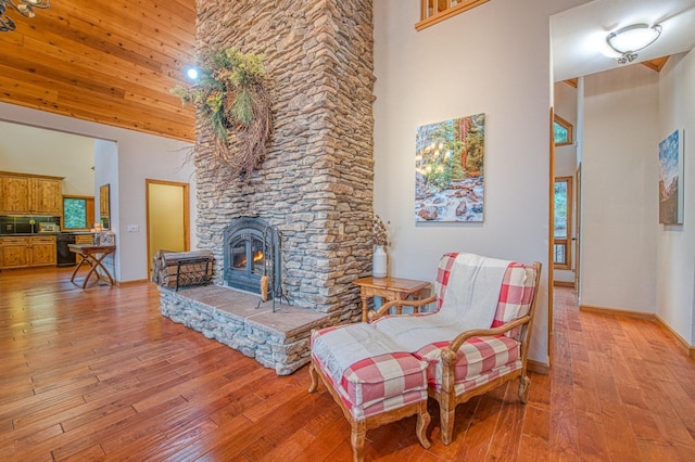 40596 Wild Iris Ln, Shaver Lake, CA 93664 - sitting room with light wood-style floors, a high ceiling, and a stone fireplace