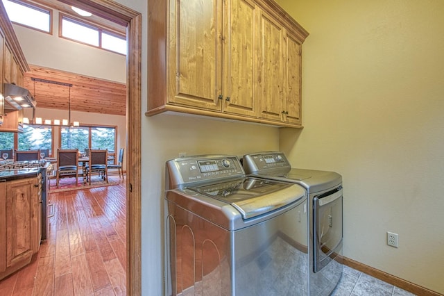 40596 Wild Iris Ln, Shaver Lake, CA 93664 - washroom with baseboards, plenty of natural light, cabinet space, and washing machine and clothes dryer