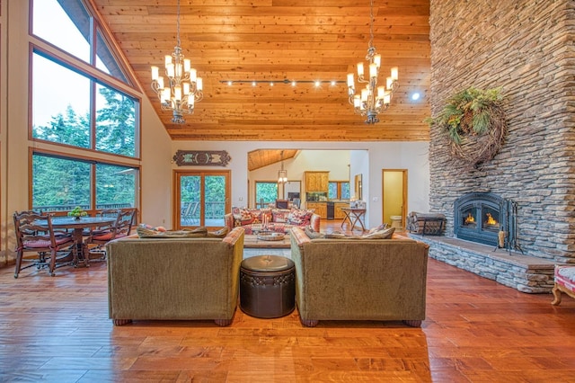 40596 Wild Iris Ln, Shaver Lake, CA 93664 - living area with an inviting chandelier, high vaulted ceiling, a stone fireplace, hardwood / wood-style floors, and wooden ceiling