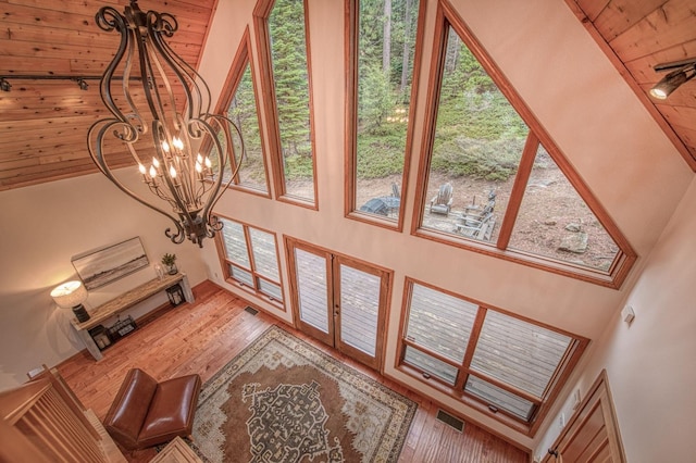 40596 Wild Iris Ln, Shaver Lake, CA 93664 - living area with wood finished floors, a high ceiling, a notable chandelier, and a healthy amount of sunlight
