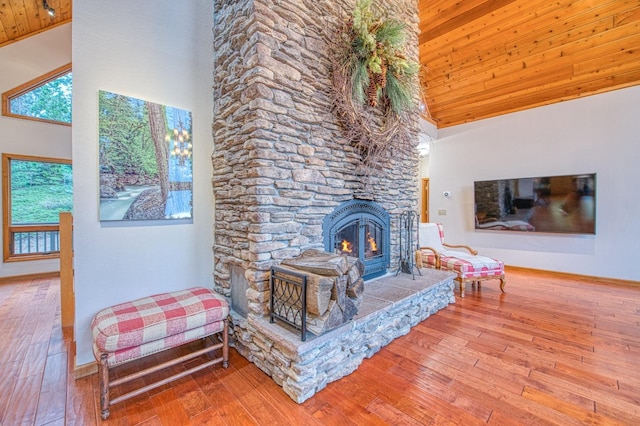 40596 Wild Iris Ln, Shaver Lake, CA 93664 - living area with wood finished floors, a stone fireplace, baseboards, high vaulted ceiling, and wooden ceiling