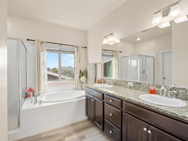 bathroom featuring a garden tub, a sink, double vanity, and a shower stall