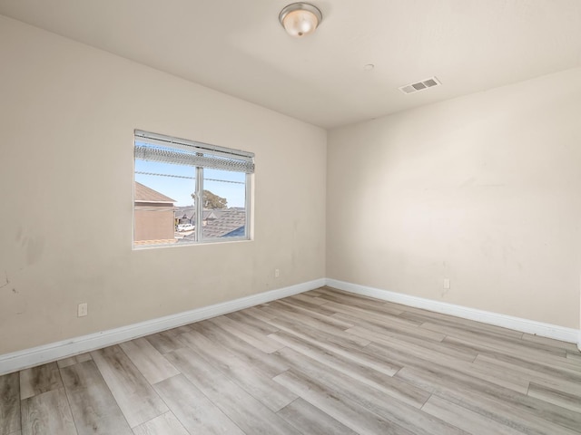 unfurnished room featuring baseboards, visible vents, and light wood-type flooring
