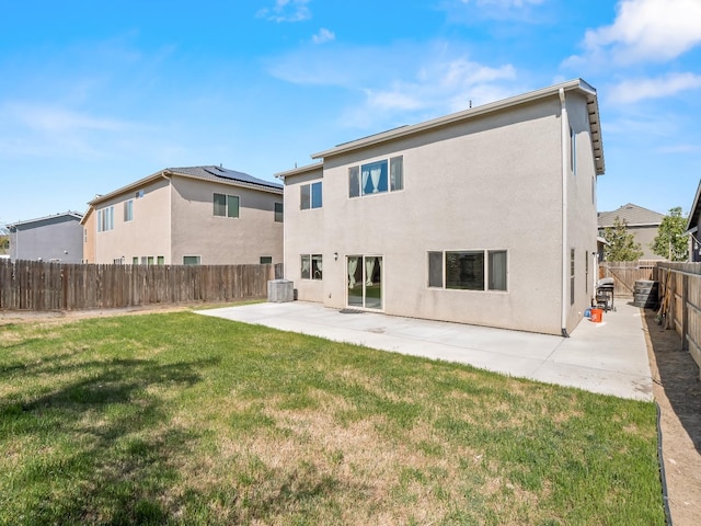 back of property with stucco siding, a fenced backyard, central AC unit, a patio, and a yard