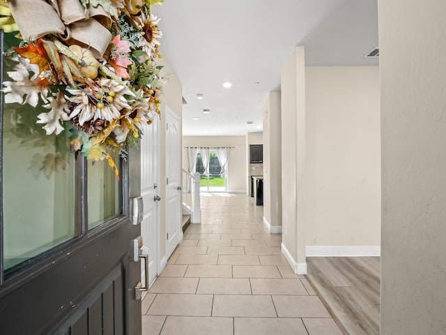 corridor featuring baseboards, recessed lighting, and light tile patterned flooring