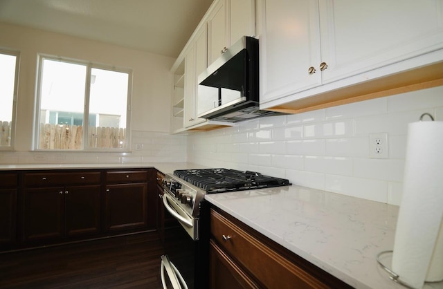 kitchen featuring light stone countertops, appliances with stainless steel finishes, white cabinetry, decorative backsplash, and dark wood-type flooring