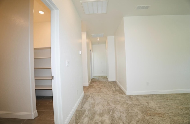 corridor featuring carpet floors, baseboards, and visible vents