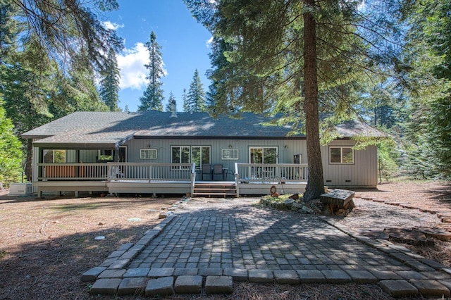 rear view of house with a patio, roof with shingles, and a deck