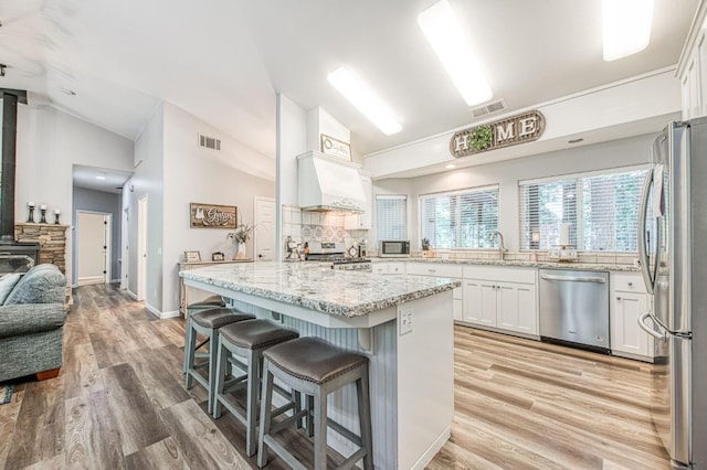 kitchen with vaulted ceiling, appliances with stainless steel finishes, and visible vents