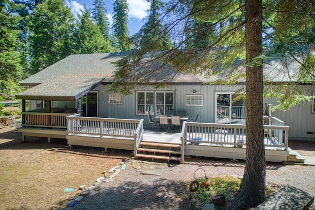 view of front of house featuring a shingled roof and a deck
