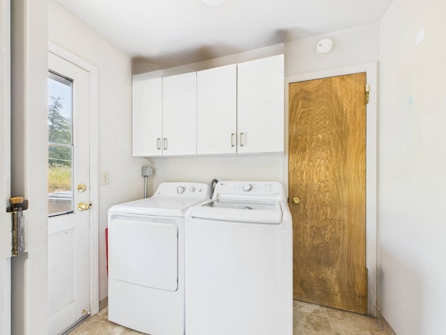 clothes washing area featuring cabinet space and washing machine and clothes dryer