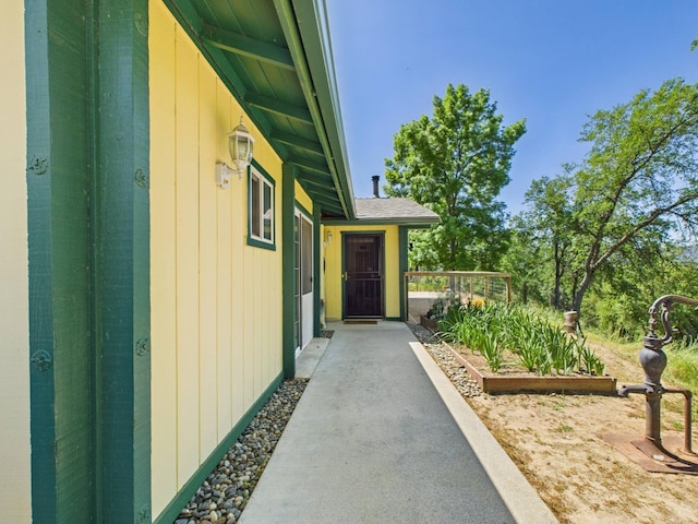 view of side of property featuring a garden and roof with shingles