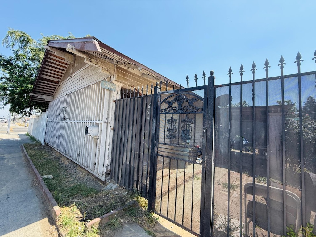 view of outbuilding featuring fence and a gate