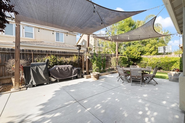 view of patio featuring a fenced backyard, outdoor dining space, and grilling area