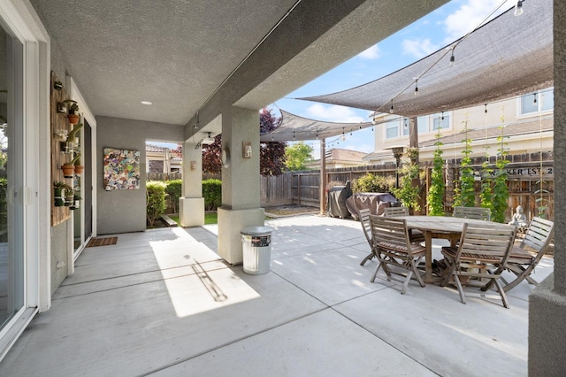 view of patio featuring fence and outdoor dining area