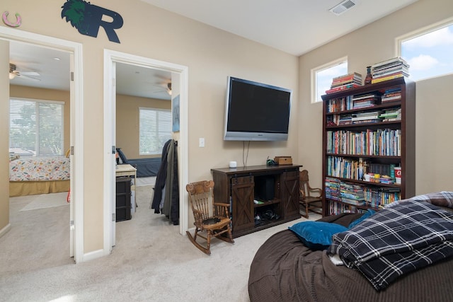 living area with carpet floors, ceiling fan, and visible vents