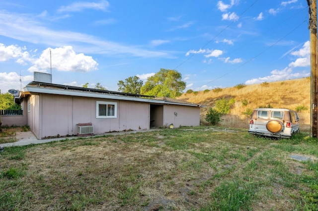 back of property featuring central air condition unit and solar panels