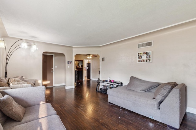 living area with visible vents, wood-type flooring, baseboards, ceiling fan, and arched walkways