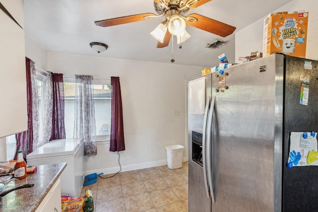 kitchen featuring ceiling fan, stainless steel refrigerator with ice dispenser, light tile patterned floors, baseboards, and white cabinets