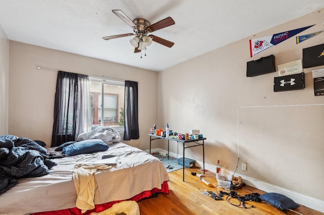 bedroom with baseboards, a ceiling fan, and wood finished floors