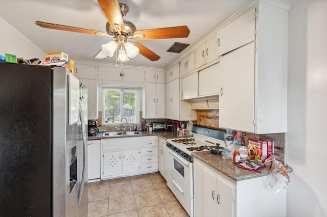 kitchen with a sink, white appliances, a ceiling fan, tasteful backsplash, and visible vents