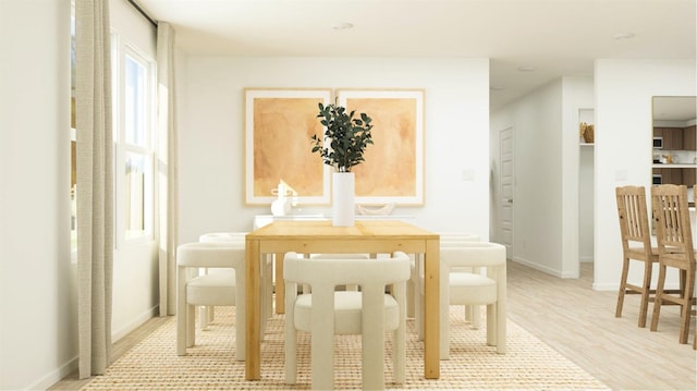 dining room featuring light wood-style floors and baseboards