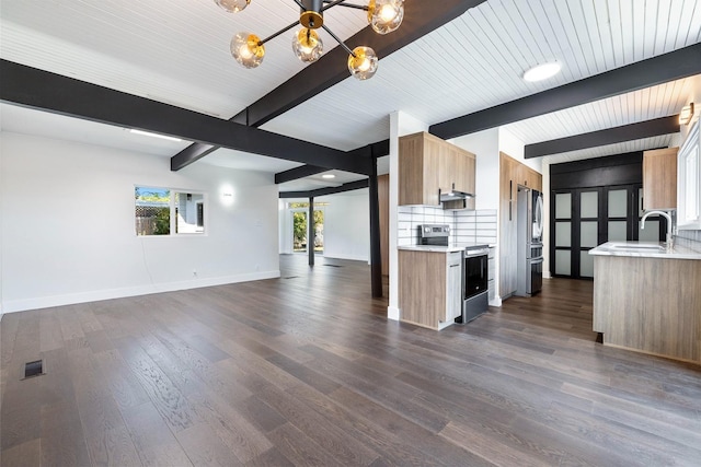 kitchen with light countertops, stainless steel appliances, open floor plan, and a sink