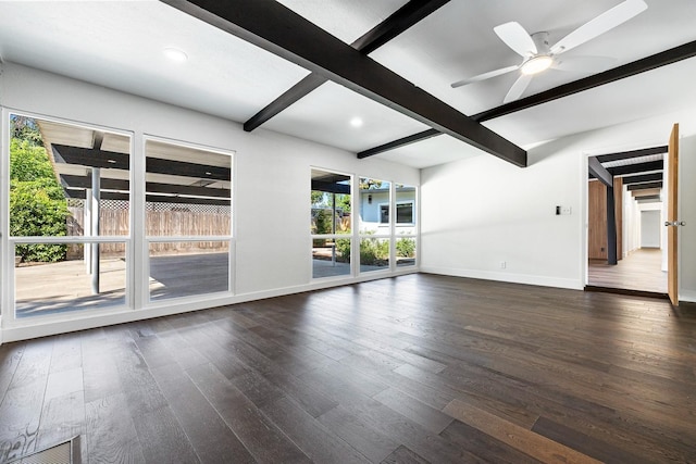 spare room featuring baseboards, dark wood-style floors, and beam ceiling