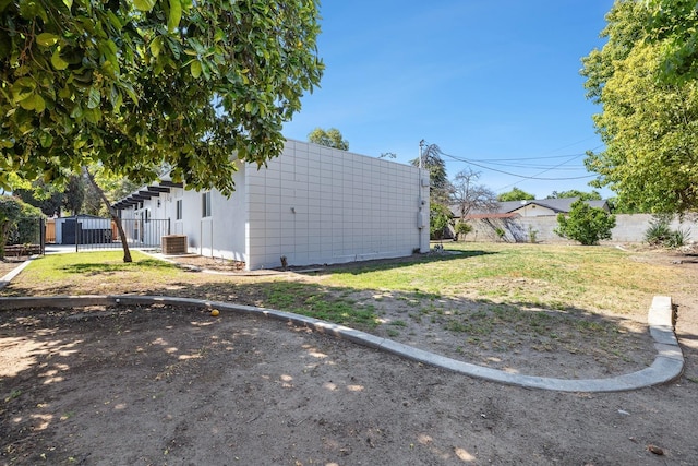 view of yard with fence and central AC unit