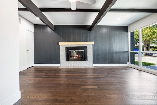 unfurnished living room with ceiling fan, a fireplace with flush hearth, beam ceiling, wood finished floors, and baseboards