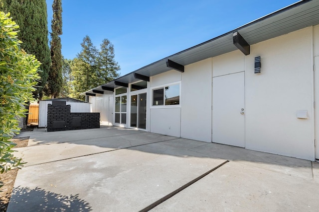 back of house with a patio area, stucco siding, and fence