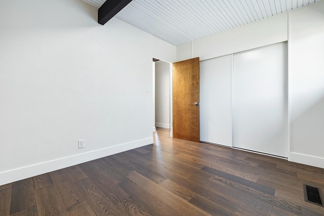 unfurnished bedroom featuring baseboards, visible vents, wood finished floors, and a closet