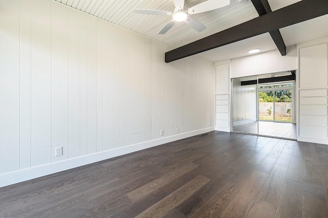 spare room featuring baseboards, a ceiling fan, beam ceiling, and dark wood-type flooring