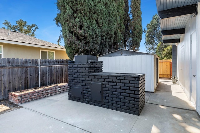 view of patio with an outdoor structure, a fenced backyard, and outdoor dry bar