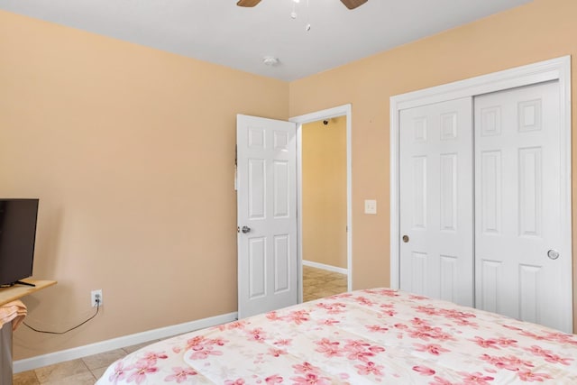 bedroom with a ceiling fan, baseboards, light tile patterned flooring, and a closet