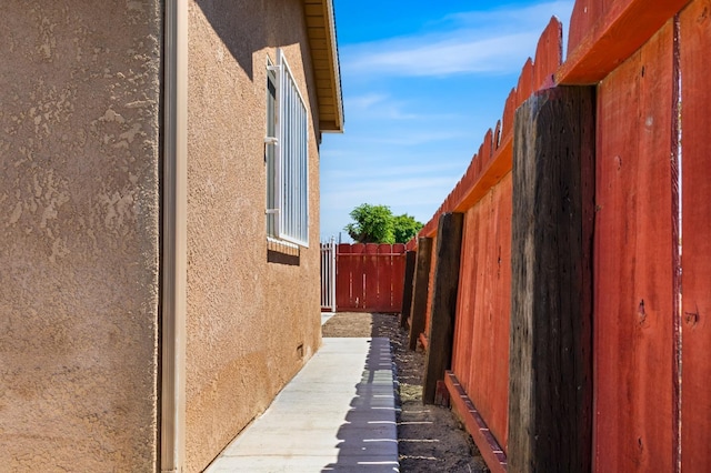 view of side of property with fence and stucco siding