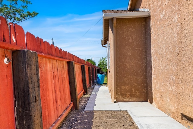 view of side of property featuring stucco siding and fence