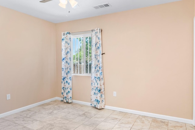 empty room featuring ceiling fan, visible vents, and baseboards