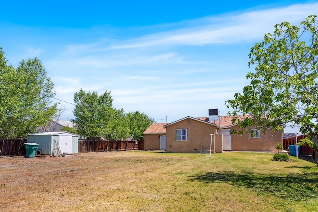 view of yard with an outdoor structure, a shed, and a fenced backyard