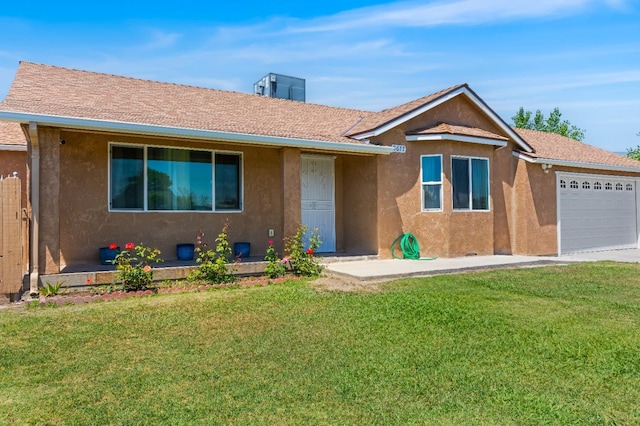single story home featuring an attached garage, a front yard, and stucco siding