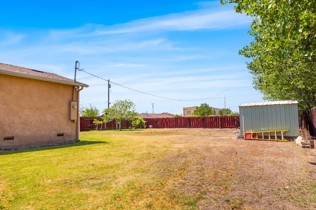 view of yard with a fenced backyard and an outbuilding
